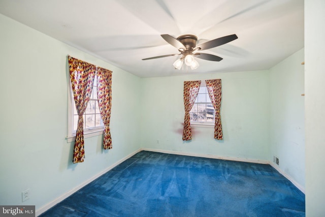 empty room with dark colored carpet and ceiling fan