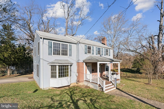 view of front of home with covered porch and a front lawn