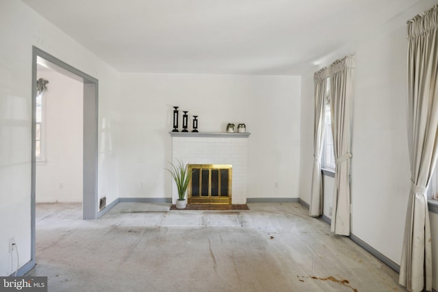 unfurnished living room featuring a brick fireplace