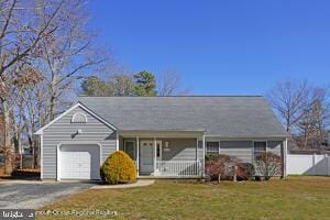 ranch-style house with a garage, covered porch, and a front yard