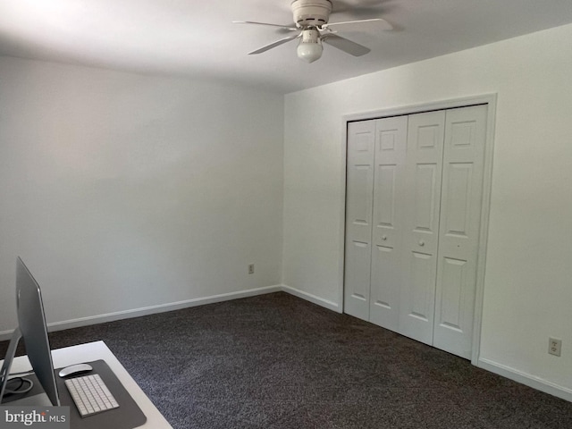 unfurnished bedroom with dark colored carpet, ceiling fan, and a closet