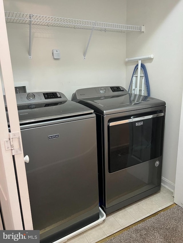 laundry room featuring light tile patterned flooring and washing machine and dryer