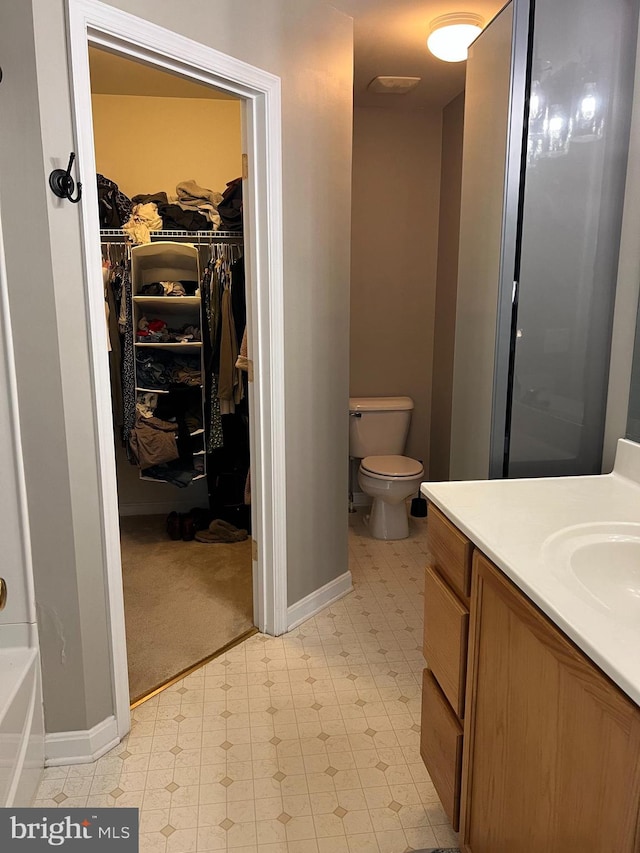 bathroom featuring vanity, toilet, and walk in shower