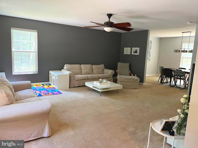 living room featuring light colored carpet and ceiling fan