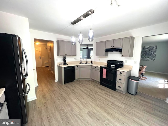 kitchen with sink, black appliances, decorative light fixtures, gray cabinets, and light hardwood / wood-style floors