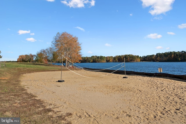 view of home's community with volleyball court and a water view