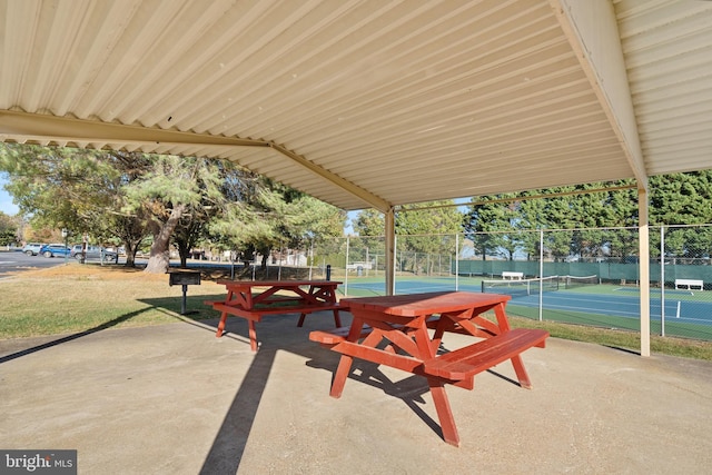 view of community featuring tennis court