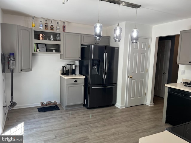 kitchen with fridge with ice dispenser, gray cabinetry, hanging light fixtures, black dishwasher, and light hardwood / wood-style floors