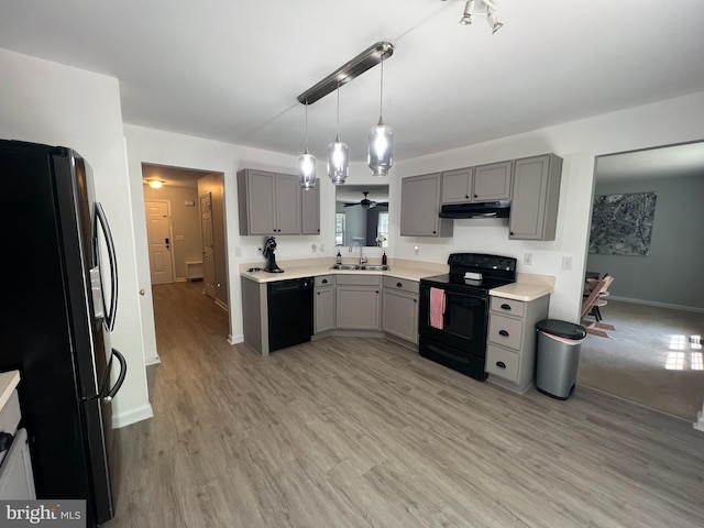 kitchen with black appliances, sink, light hardwood / wood-style flooring, gray cabinets, and decorative light fixtures