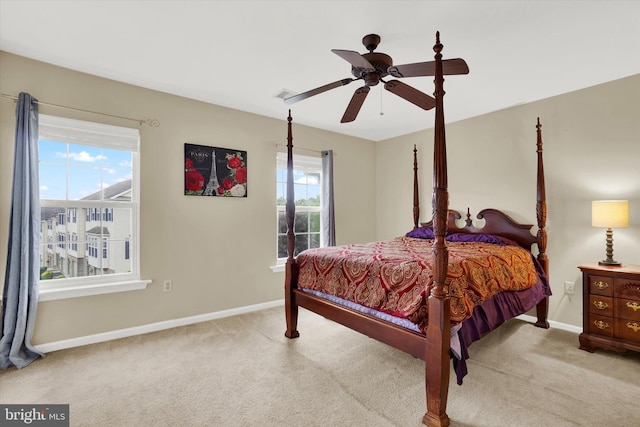 carpeted bedroom with multiple windows and ceiling fan