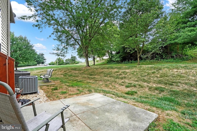 view of yard with central AC unit and a patio area