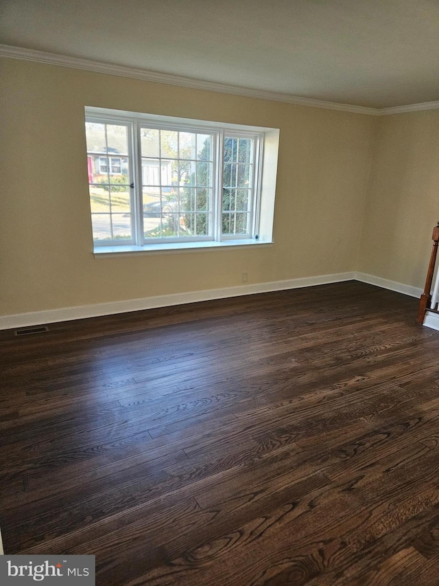 spare room featuring dark hardwood / wood-style floors and ornamental molding