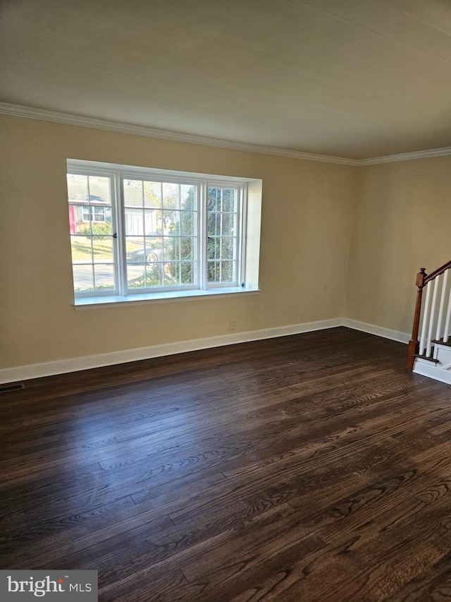 empty room featuring crown molding and dark wood-type flooring