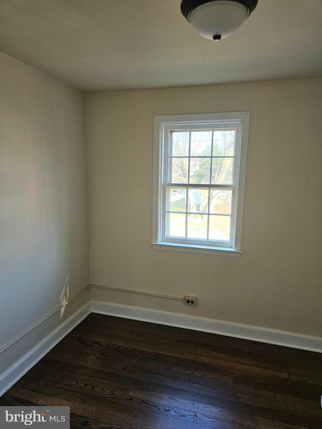 spare room with dark wood-type flooring