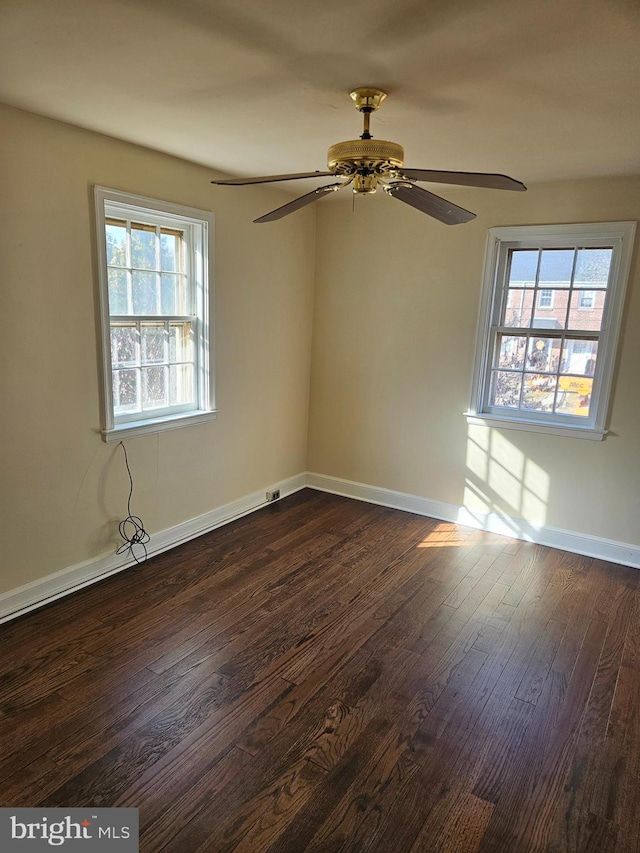 empty room with ceiling fan, dark hardwood / wood-style flooring, and a healthy amount of sunlight