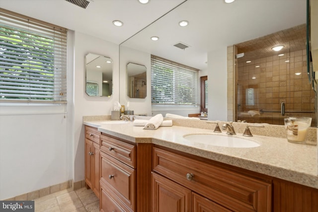 bathroom featuring tile patterned flooring, vanity, and a shower with shower door