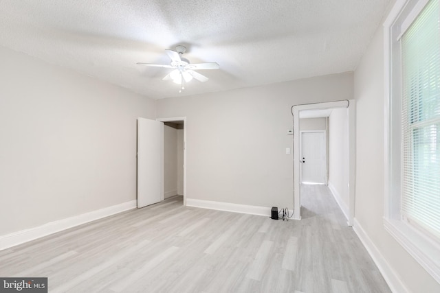 spare room with ceiling fan, a textured ceiling, and light hardwood / wood-style flooring