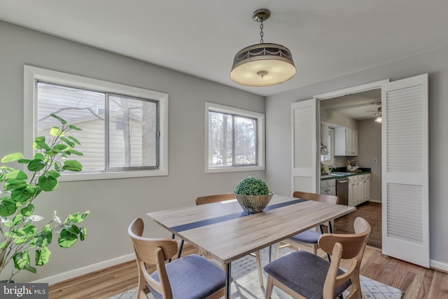 dining space featuring light wood-style flooring and baseboards