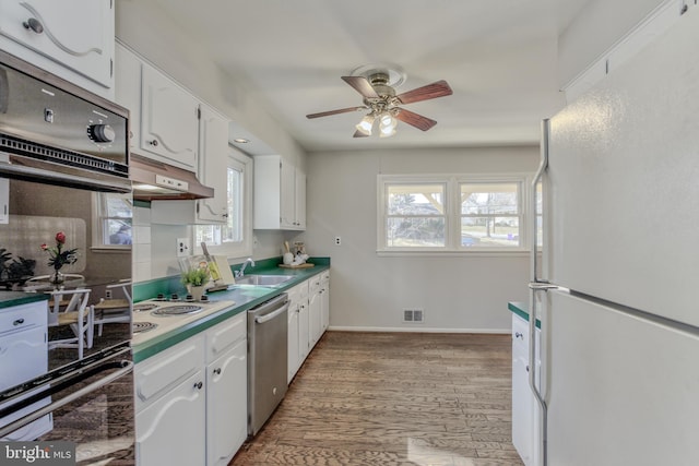 kitchen featuring white appliances, white cabinetry, visible vents, and under cabinet range hood