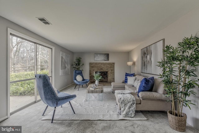 living area featuring a brick fireplace, visible vents, and baseboards