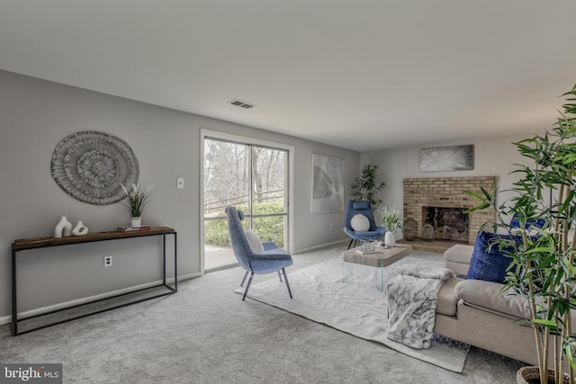 carpeted living room with a brick fireplace, baseboards, and visible vents