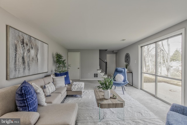 living area with stairs, carpet, visible vents, and baseboards