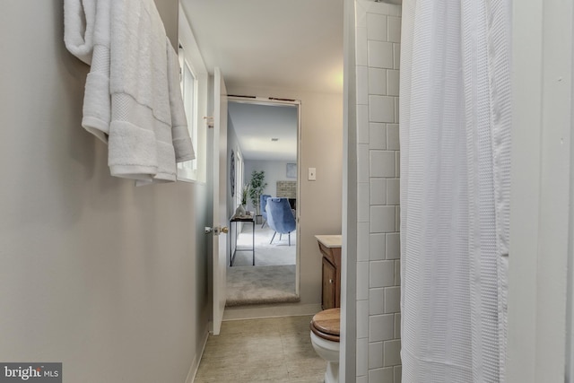 bathroom featuring a shower with curtain, baseboards, vanity, and toilet