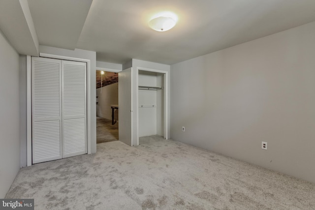 unfurnished bedroom featuring two closets and carpet flooring