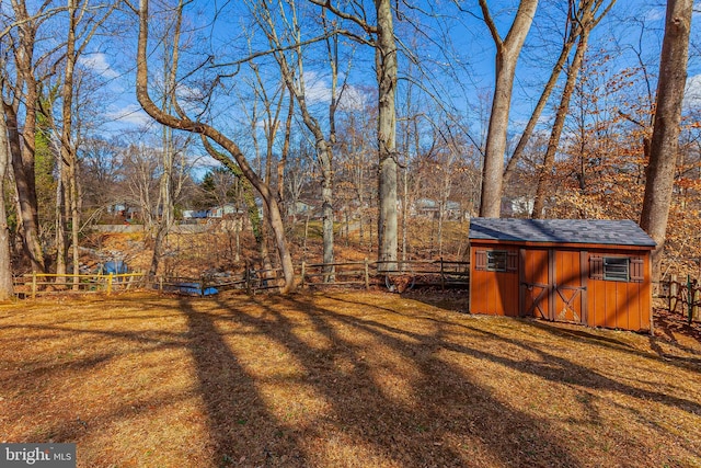 view of yard featuring an outbuilding, a fenced backyard, and a storage shed