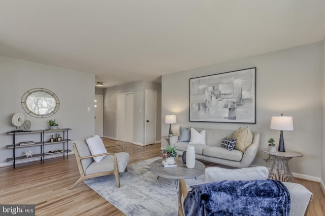 living area with baseboards and wood finished floors