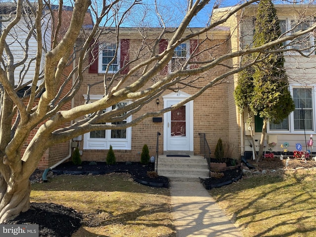 view of front of property with brick siding and a front lawn