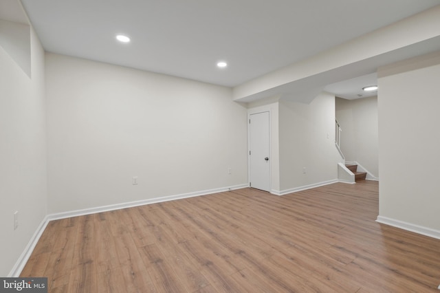 finished below grade area with stairs, wood finished floors, and baseboards