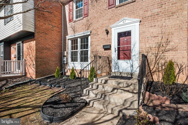 view of exterior entry with brick siding