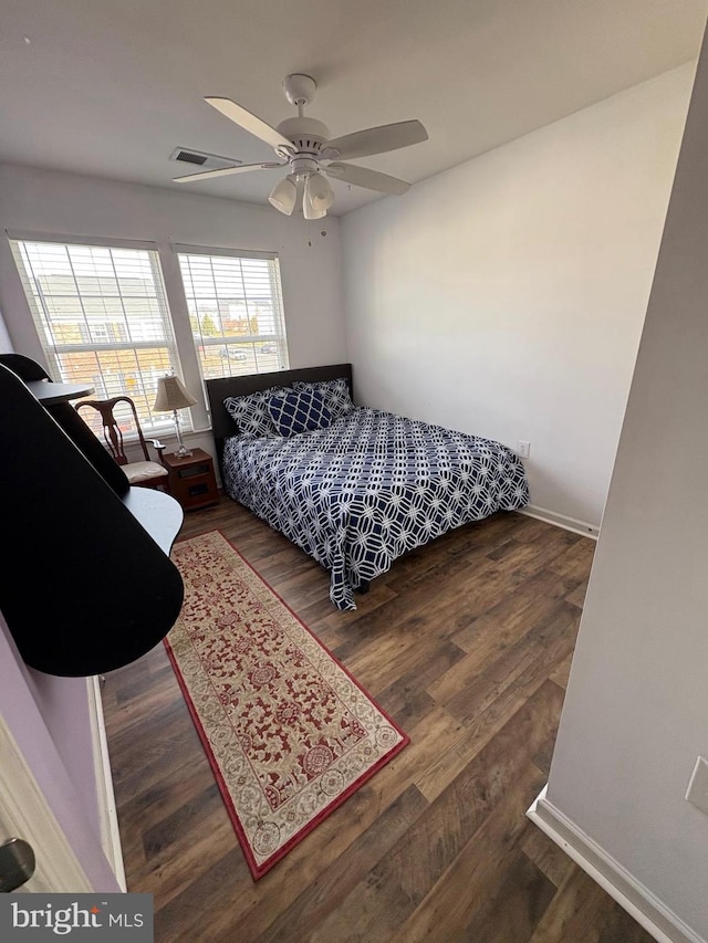 bedroom with dark hardwood / wood-style floors and ceiling fan