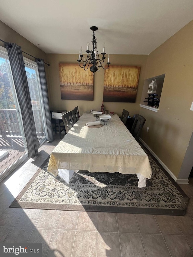 dining space with tile patterned flooring and a chandelier