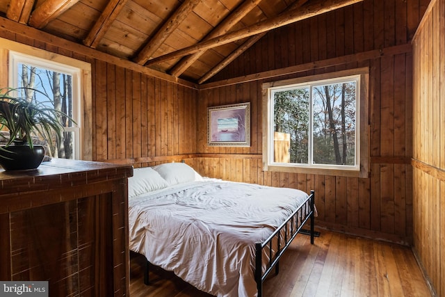 bedroom with multiple windows, wooden walls, dark hardwood / wood-style flooring, and wood ceiling