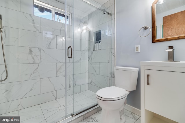 bathroom featuring vanity, a shower with shower door, and toilet