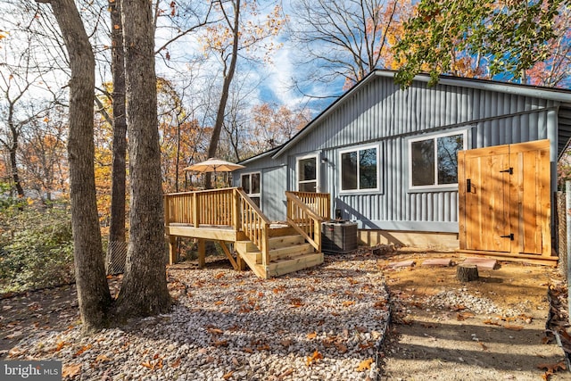 rear view of house with central AC and a wooden deck