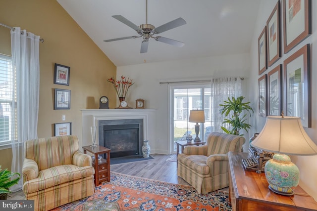 living room with ceiling fan, lofted ceiling, and light wood-type flooring