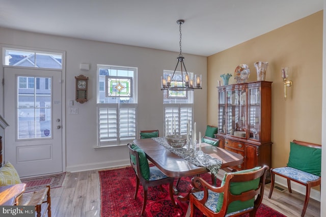 dining space featuring a chandelier, light hardwood / wood-style flooring, and a wealth of natural light