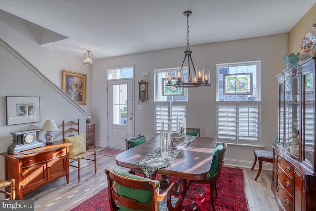 dining space with light hardwood / wood-style flooring, a chandelier, and plenty of natural light