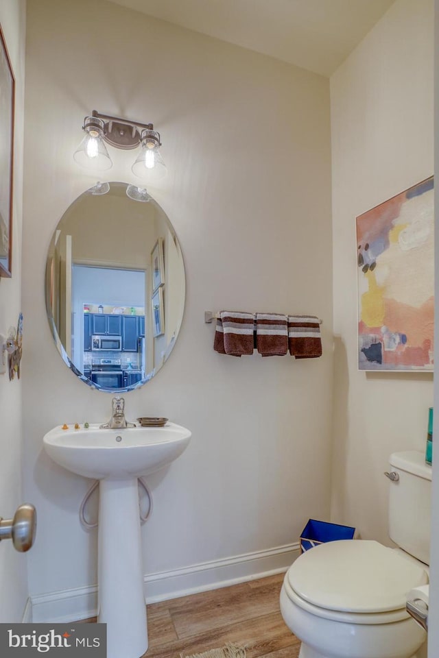 bathroom featuring wood-type flooring and toilet