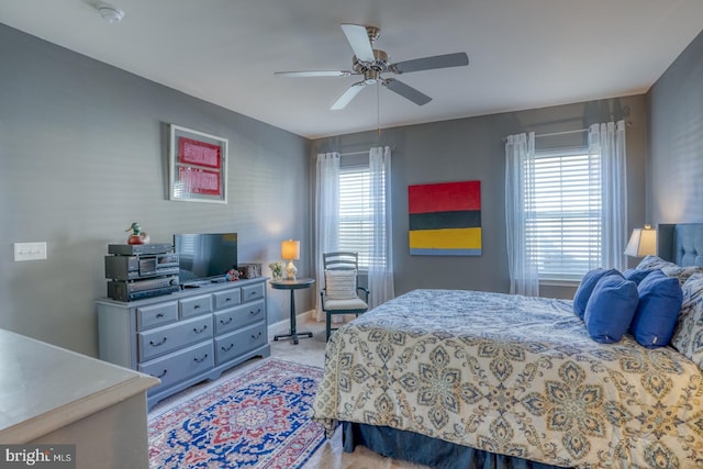 carpeted bedroom featuring multiple windows and ceiling fan