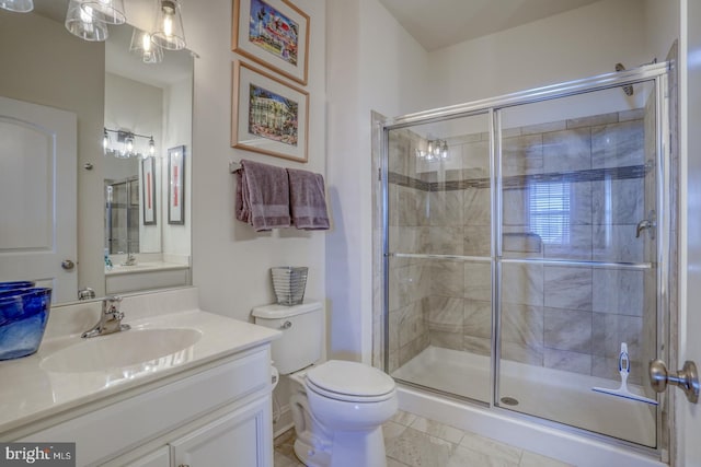 bathroom with tile patterned flooring, a shower with door, vanity, and toilet