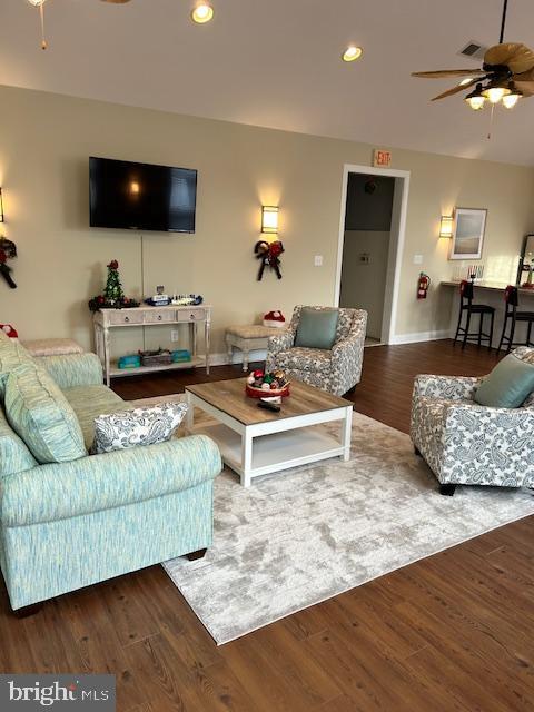 living room with ceiling fan and dark hardwood / wood-style floors