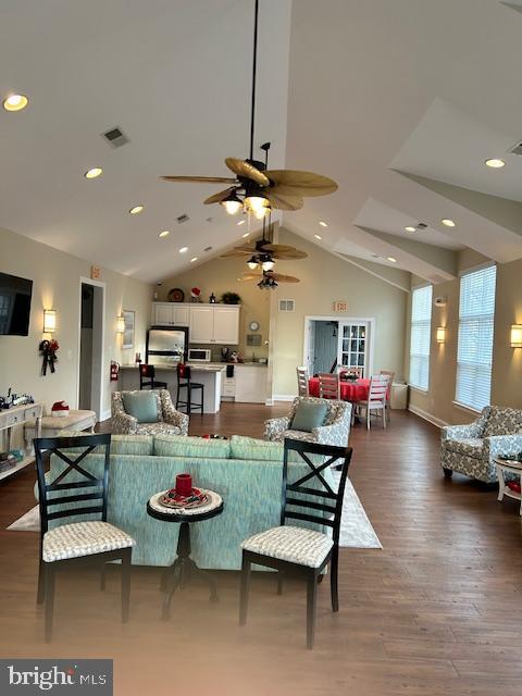 living room with ceiling fan, dark wood-type flooring, and high vaulted ceiling