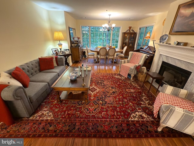 living room featuring a fireplace, a notable chandelier, and hardwood / wood-style flooring