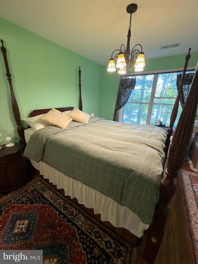 bedroom featuring a chandelier and wood-type flooring