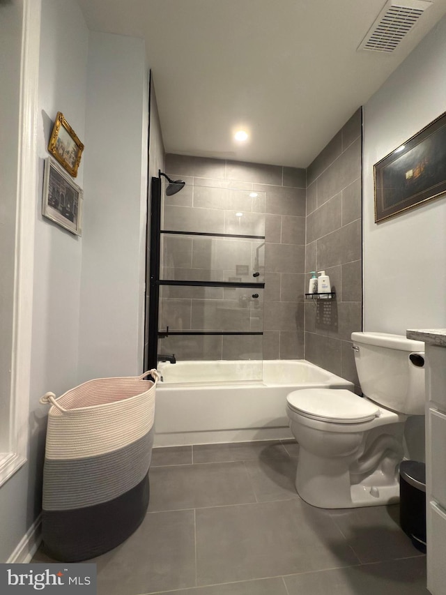 bathroom featuring tile patterned floors, toilet, and tiled shower / bath