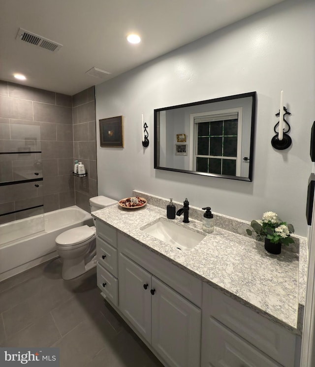 full bathroom featuring tile patterned flooring, vanity, toilet, and tiled shower / bath combo